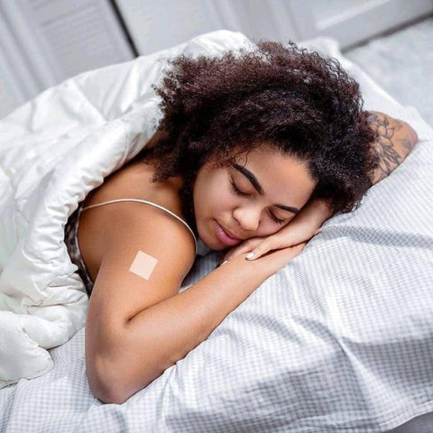 Eden’s Market PatchAid sleep aid vitamin patch applied to the shoulder of a woman sleeping peacefully in bed