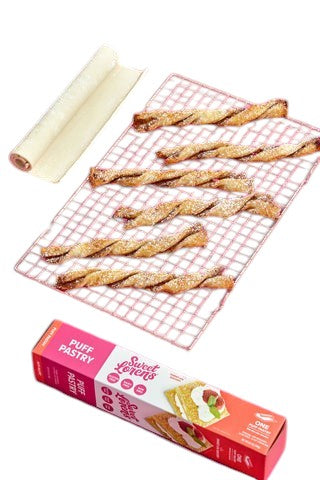 Eden’s Market Sweet Loren's gluten-free puff pastry dough with baked pastry twists on a cooling rack, pink background.