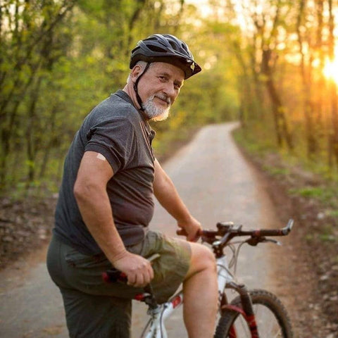 Eden’s Market PatchAid sleep aid vitamin patch applied to the arm of an older man cycling on a path at sunset
