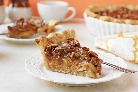 Eden’s Market slice of pumpkin pecan pie with a flaky crust on a white decorative plate